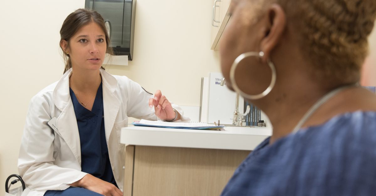 Médica orientando paciente durante consulta