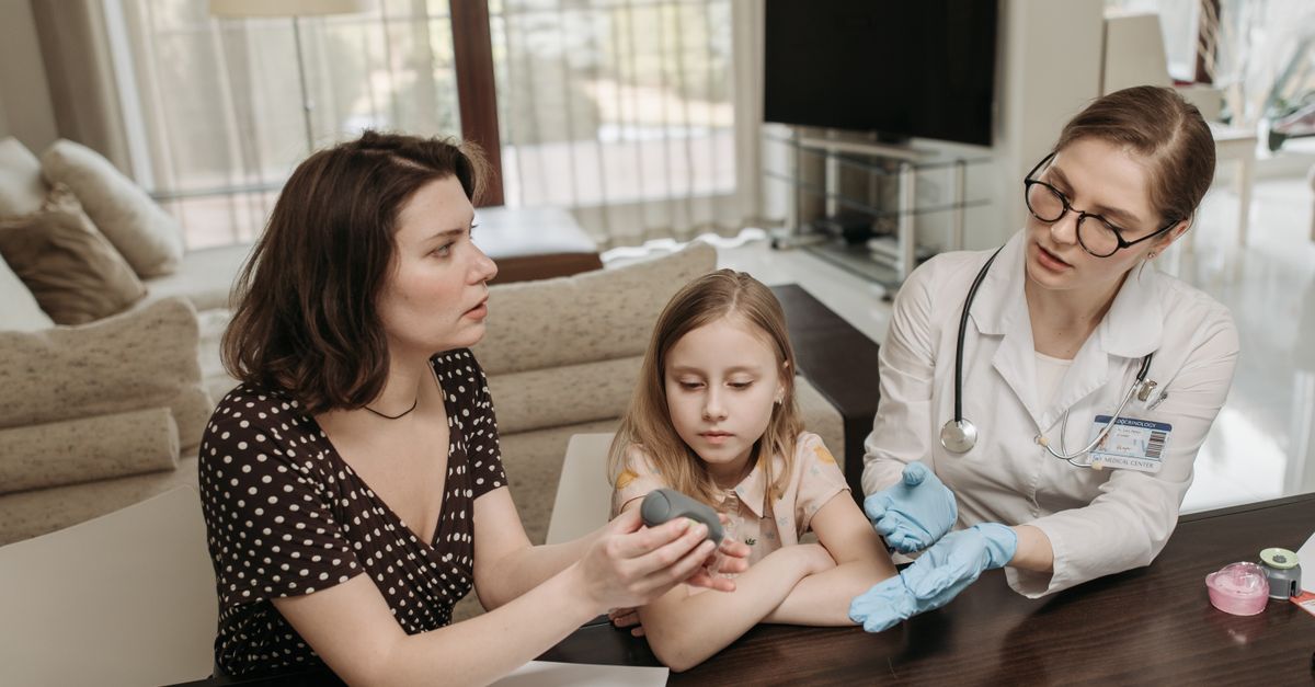 Mãe e filha conversam com profissional de saúde em ambiente tranquilo